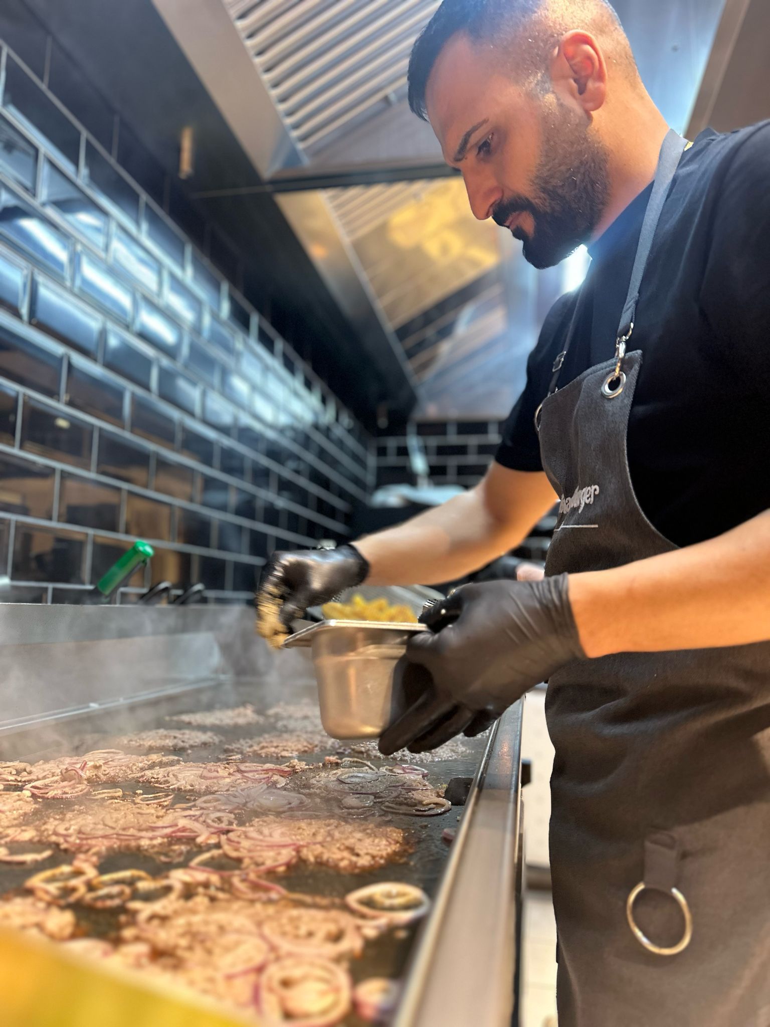 Chef bereitet Smash Burger frisch in Baden zu
